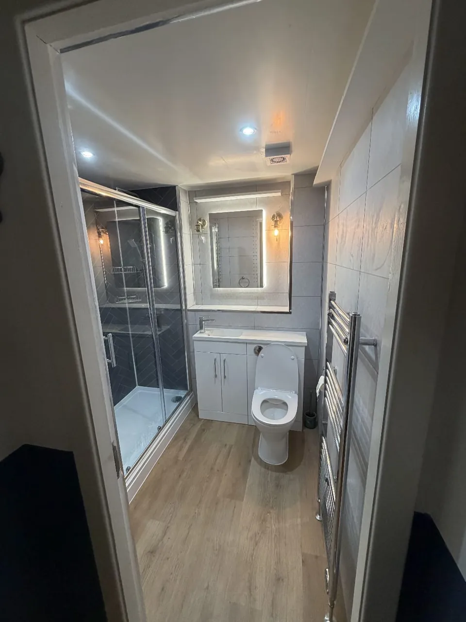 Glass shower enclosure with navy herringbone tiles